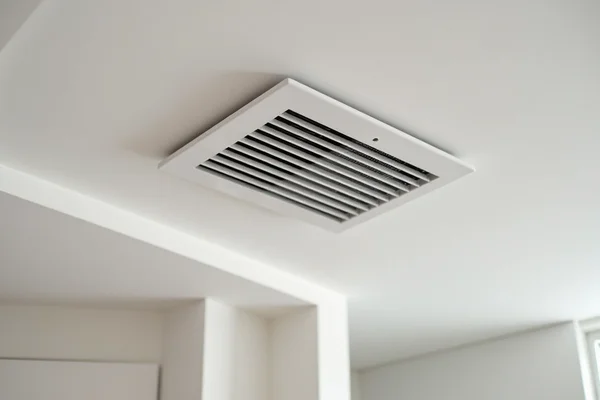 Modern bathroom exhaust fan being installed in ceiling by electrician