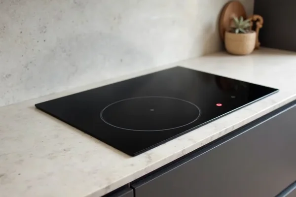 Smooth black induction cooktop installed in stone countertop with clean finish