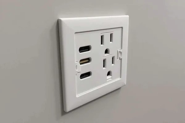 Electrician installing a modern power point with integrated USB charging ports in bedroom wall