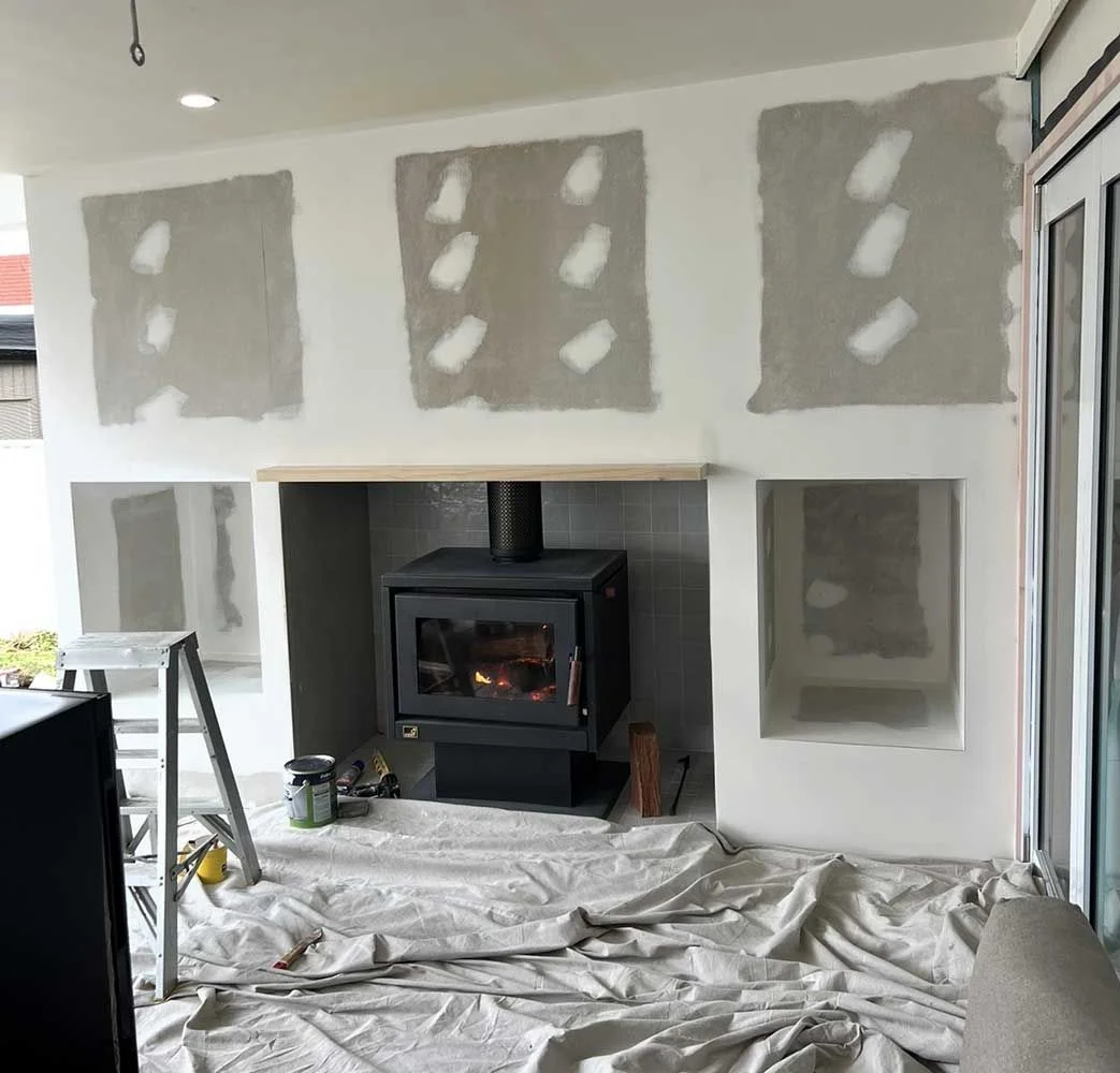 Fireplace and living area renovation in progress — plastering, wood heater installation by MTS Group