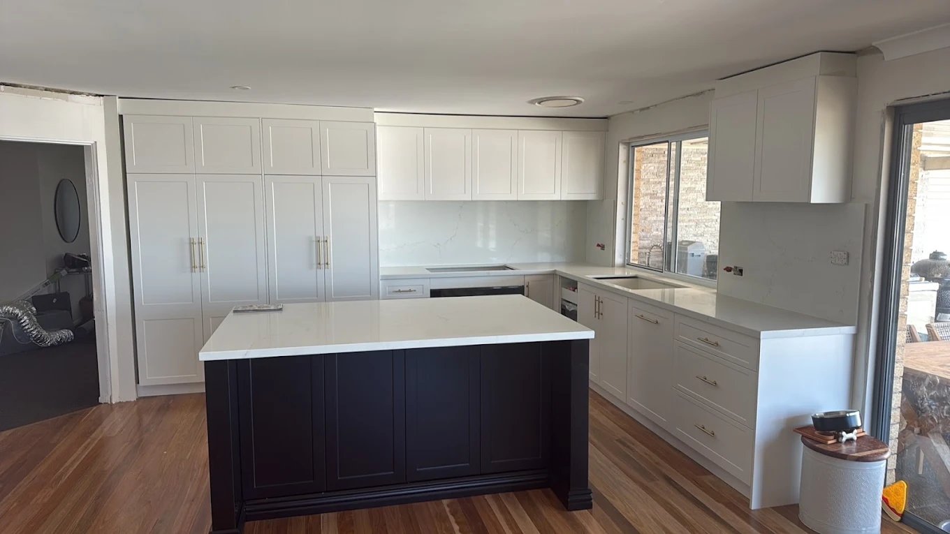 Kitchen renovation with navy island bench, white shaker cabinetry, stone benchtop and timber floors by MTS Group
