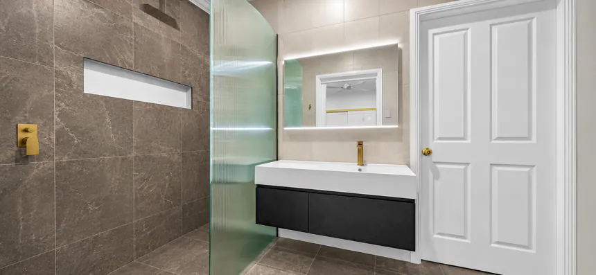 Stone tiled ensuite with concealed shower mixer and wall-hung vanity