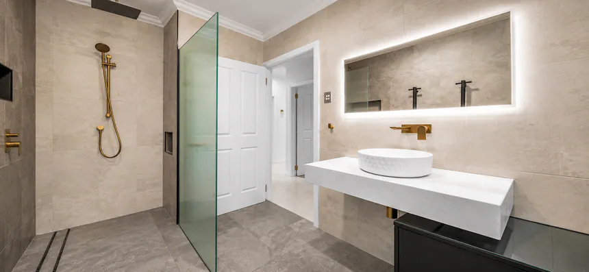 Walk-in shower and backlit mirror in a completed bathroom renovation
