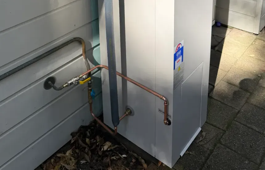 Gas line, isolation valve and copper pipework at the base of a gas storage hot water unit installed by Vicinity Plumbing